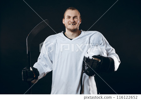 Handsome hockey player. Smiling at camera isolated on black background. Handsome hockey player. Smiling at camera isolated on black background. 116122652