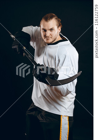 Hockey player shoots the puck and attacks, isolated over black background. Hockey player shoots the puck and attacks, isolated over black background. 116122759