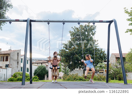 mother with two daughters in children playground 116122891