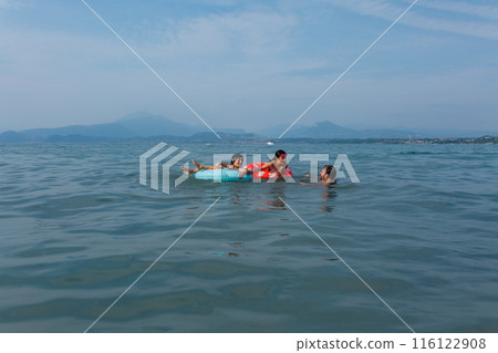 father and two children swimming together in the lake father and two children swimming together in the lake 116122908