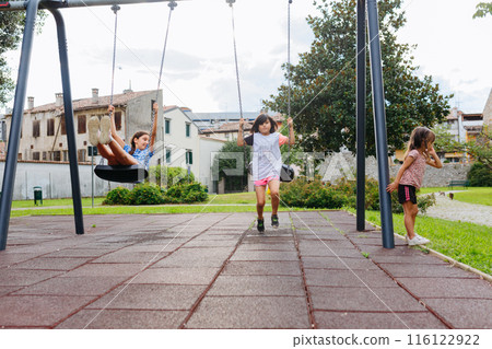 three girls playing at children playground outdoors 116122922