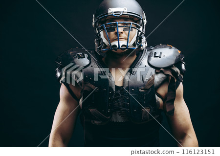 Portrait of american football player in protective shields on naked torso Portrait of american football player in protective shields on naked torso 116123151