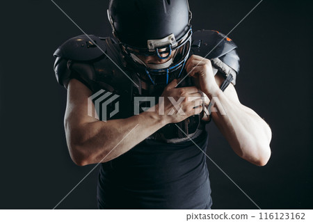 American football player with ball wearing helmet and protective shields American football player with ball wearing helmet and protective shields 116123162