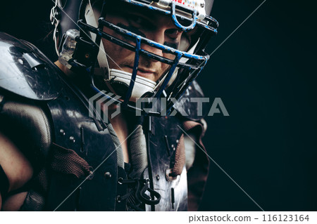 American football player with ball wearing helmet and protective shields 116123164