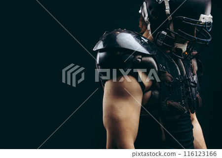 American football player with ball wearing helmet and protective shields 116123166