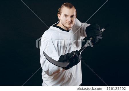Hockey player shoots the puck and attacks, isolated over black background. Hockey player shoots the puck and attacks, isolated over black background. 116123202