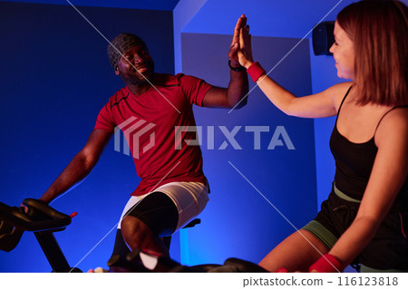 African American man and young woman high fiving and supporting each other while they burning calories 116123818