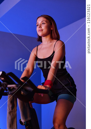 Low angle shot of young pretty woman doing cardio train to burn calories 116123821