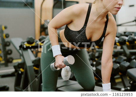 Medium close up of female body doing exercise for shoulder and back muscles 116123953