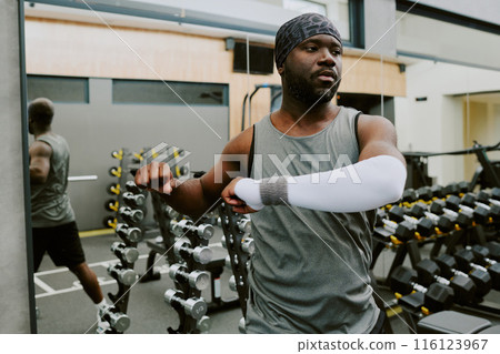 Young African American Athlete stretching his core and back before workout 116123967