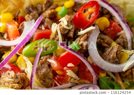 Mexican taco filling with beef, onions, hot peppers, corn, tomatoes and cheese. Close up. Authentic tacos, birria, carne asada, adobada, cabeza and chicharron. Homemade appetizers. 116124254