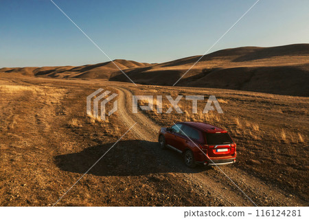 Red Car Driving on Dirt Road in Georgia Red Car Driving on Dirt Road in Georgia 116124281