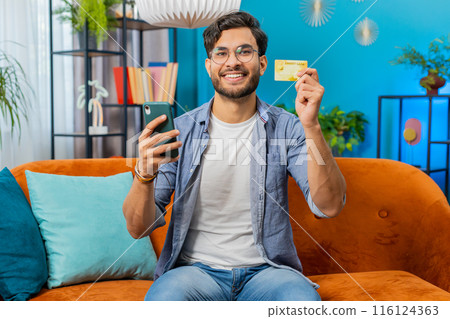 Middle eastern man using credit bank card, smartphone transferring money purchases online shopping Middle eastern man using credit bank card, smartphone transferring money purchases online shopping 116124363