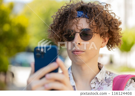 Tourist man using smartphone typing texting social media messages e-mail looking for a way on map 116124408