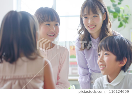 Elementary school students and staff talking at an after-school facility_1 116124609