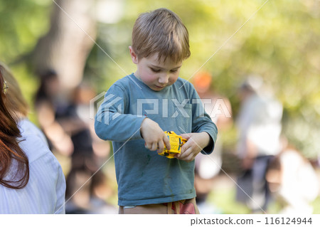 A boy is playing with a toy car 116124944