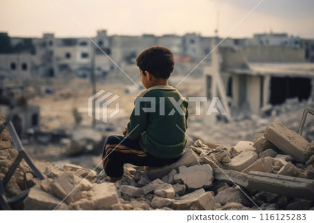 A child sits on the ruins of his house after the bombing 116125283