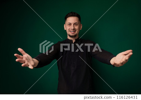 Man Standing in Front of Green Wall 116126431