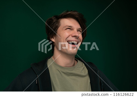 Man Laughing in Front of Green Background 116126622
