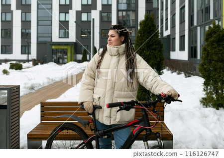 Woman Sitting on Bench Next to Bike 116126747