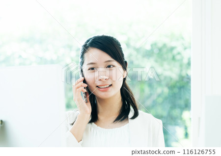 Young woman talking on a smartphone Young woman talking on a smartphone 116126755