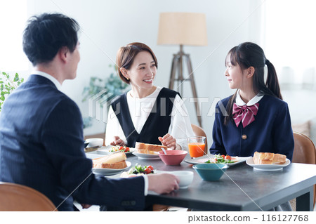 Family eating breakfast: girl and parents Family eating breakfast: girl and parents 116127768