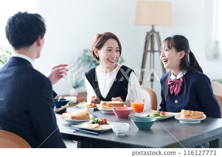 Family eating breakfast: girl and parents Family eating breakfast: girl and parents 116127771