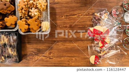 Carefully packaging Christmas cutout cookies, half-dipped in chocolate and presented in clear cellophane wrapping, perfect for festive gifting. Carefully packaging Christmas cutout cookies, half-dipped in chocolate and presented in clear cellophane wrapping, perfect for festive gifting. 116128447