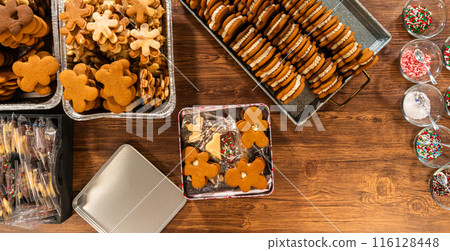 Lovingly homemade gingerbread and sugar cookies, half-dipped in rich chocolate, nestled in decorative Christmas tin boxes perfect for seasonal gifting. 116128448