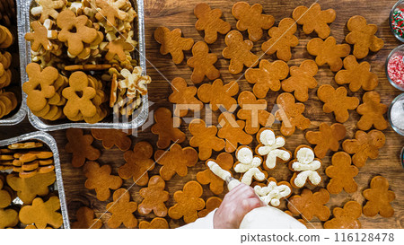 Flat lay. Crafting gingerbread cookie sandwiches with eggnog buttercream, presented on a rustic wooden table for Christmas gifting. Flat lay. Crafting gingerbread cookie sandwiches with eggnog buttercream, presented on a rustic wooden table for Christmas gifting. 116128478
