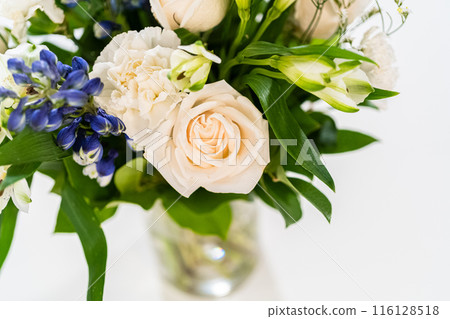 A stunning bouquet featuring fresh white roses and assorted flowers gracefully arranged in a vase, exuding timeless beauty. 116128518