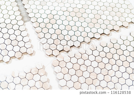 In the process of mounting peel and stick mosaic tiles onto a foam board, perfect for enhancing a food photography studio's aesthetic. 116128538