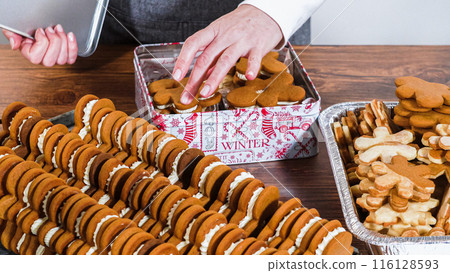 Lovingly homemade gingerbread and sugar cookies, half-dipped in rich chocolate, nestled in decorative Christmas tin boxes perfect for seasonal gifting. 116128593
