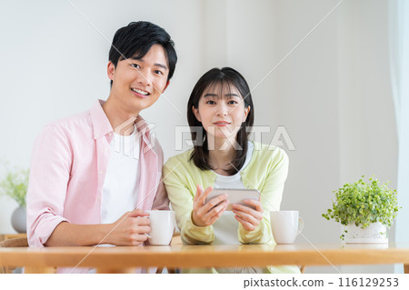 Young couple watching videos on their smartphones Young couple watching videos on their smartphones 116129253