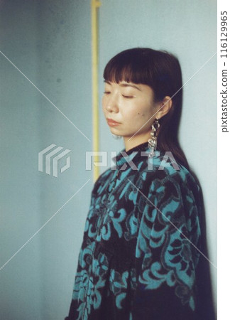 一個女人站在藍色房間裡的肖像 116129965