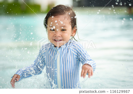 happy toddler baby playing water splashing in swimming pool 116129987