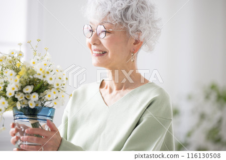 Senior woman holding flowers in her room Hobbies of gardening and flowers 116130508