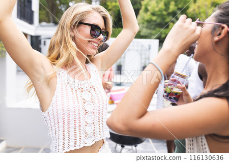 A group of young friends enjoys a lively poolside gathering 116130636