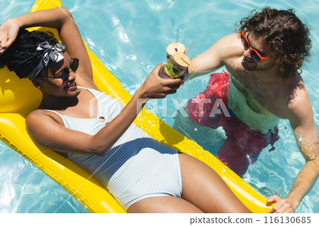 A diverse couple enjoys pool time together A diverse couple enjoys pool time together 116130685