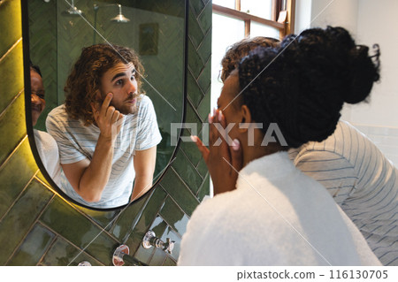 A diverse couple is in the bathroom doing their morning skincare routine A diverse couple is in the bathroom doing their morning skincare routine 116130705