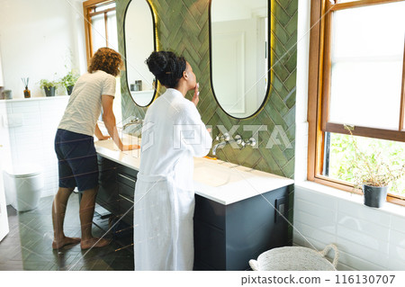 A diverse couple is in a bright bathroom A diverse couple is in a bright bathroom 116130707