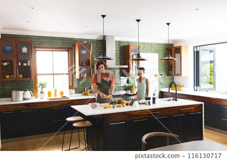 A diverse couple is preparing meal together in a modern kitchen with copy space A diverse couple is preparing meal together in a modern kitchen with copy space 116130717