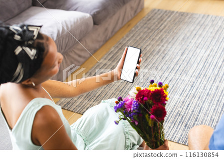 African American woman holding smartphone, showing screen on a video call date with copy space African American woman holding smartphone, showing screen on a video call date with copy space 116130854