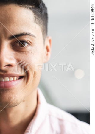 A young biracial man with brown eyes smiling in a modern business office with copy space A young biracial man with brown eyes smiling in a modern business office with copy space 116130946