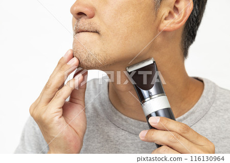 A man shaving his beard on a white background 116130964