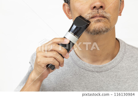 A man shaving his beard on a white background A man shaving his beard on a white background 116130984