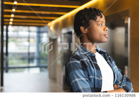 African American man standing, looking thoughtful in a modern business office with copy space 116130986
