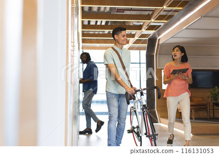 Diverse group of colleagues walking and talking in bright hallway in a modern business office Diverse group of colleagues walking and talking in bright hallway in a modern business office 116131053