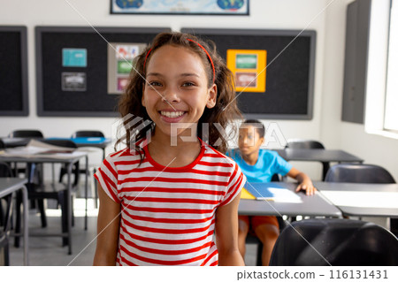 In school, in the classroom, a biracial girl and boy are focusing on learning In school, in the classroom, a biracial girl and boy are focusing on learning 116131431