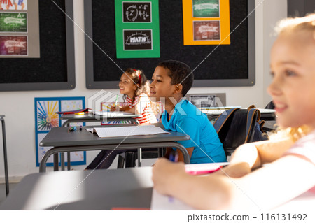 In school, diverse young students focusing on learning in the classroom In school, diverse young students focusing on learning in the classroom 116131492